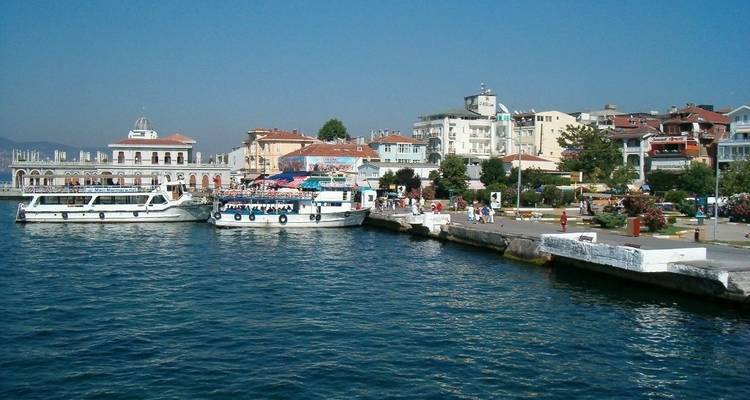 Pueblo costero con barcos atracados en un muelle bajo un cielo azul despejado.