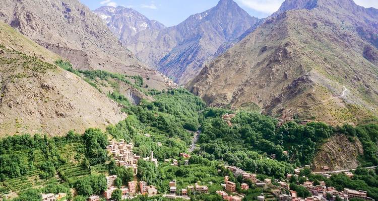 Weelderige groene vallei omringd door hoge bergen.