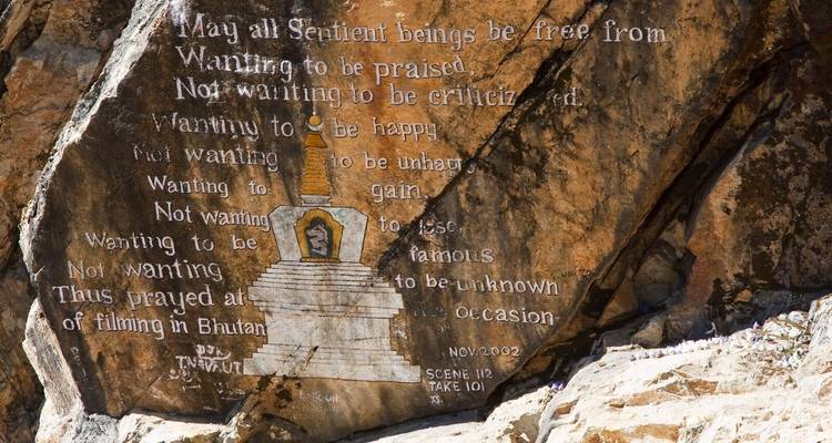 Uitgesneden inscriptie op een rots met spirituele tekst en een afbeelding.