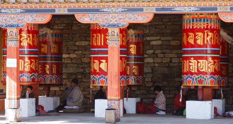 Mensen in een traditionele Bhutanese structuur met kleurrijke zuilen.