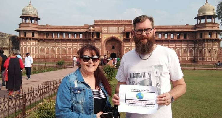 Twee mensen die een bord vasthouden voor een fort in India.