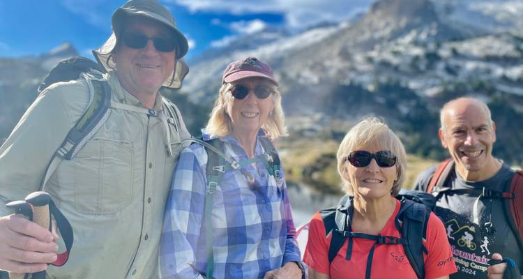 Groupe de randonneurs dans un paysage montagneux avec un ciel bleu.