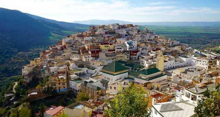 Blick auf eine kleine Stadt auf einem Hügel bei klarem Himmel