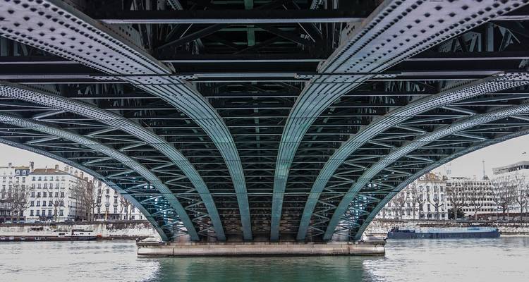 Vue symétrique des arcs en acier sous un pont enjambant le Rhône à Lyon