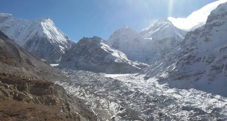 Vaste étendue de montagnes enneigées et escarpées sous un ciel dégagé.