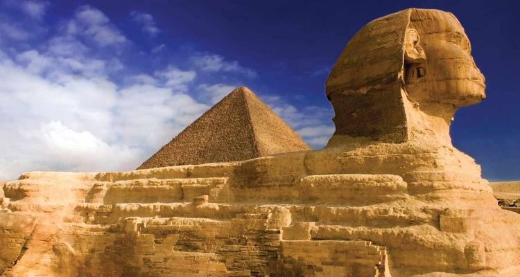 Le Grand Sphinx emblématique avec la Pyramide de Khafré s'élevant derrière lui sous un ciel désertique dramatique.