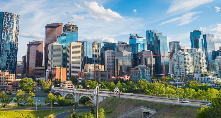 Modern skyline van Calgary met glazen wolkenkrabbers, de Bow River en Centre Street Bridge op een zonnige middag