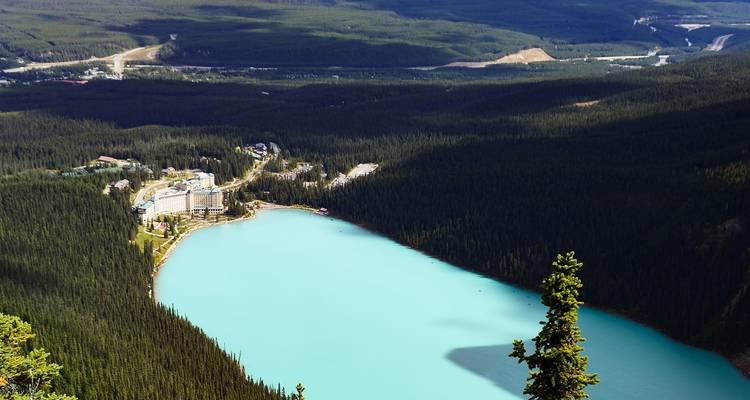 Geweldig uitzicht op een turquoise gletsjermeer omgeven door dicht bos en een resort complex