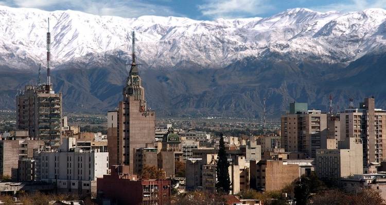 Cityscape with snowy mountain backdrop.