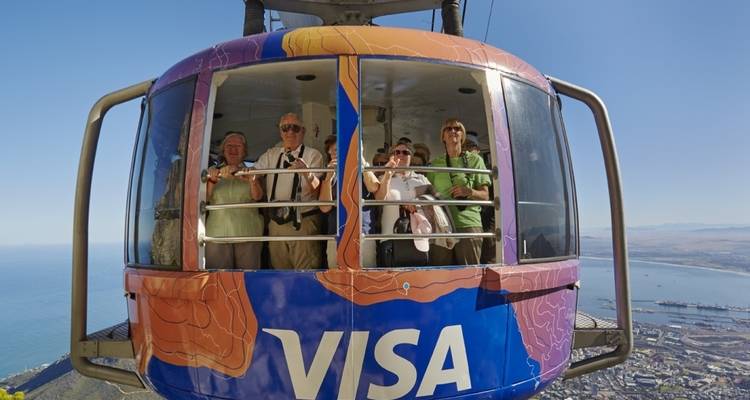 Téléphérique avec des touristes et une vue sur le littoral.