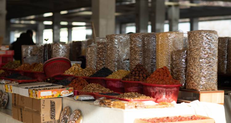 Hileras moteadas de sol con nueces, semillas y frutas secas en torres envueltas en plástico