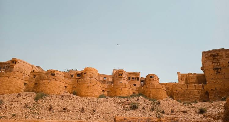Un fort construit en grès jaune contre un ciel dégagé.