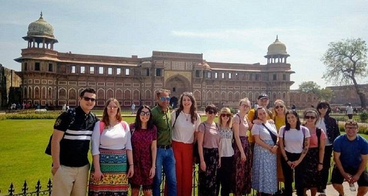 Un groupe de touristes posant devant un fort de l'époque moghole.