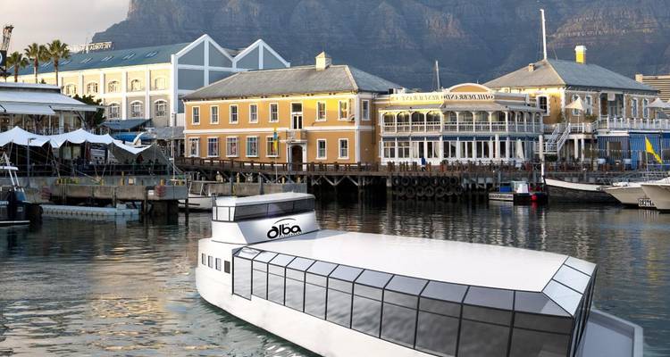 Gebouwen aan het water met bergen op de achtergrond.