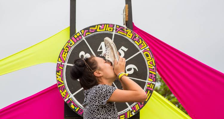 Femme buvant dans une chaussure devant un plateau de jeu