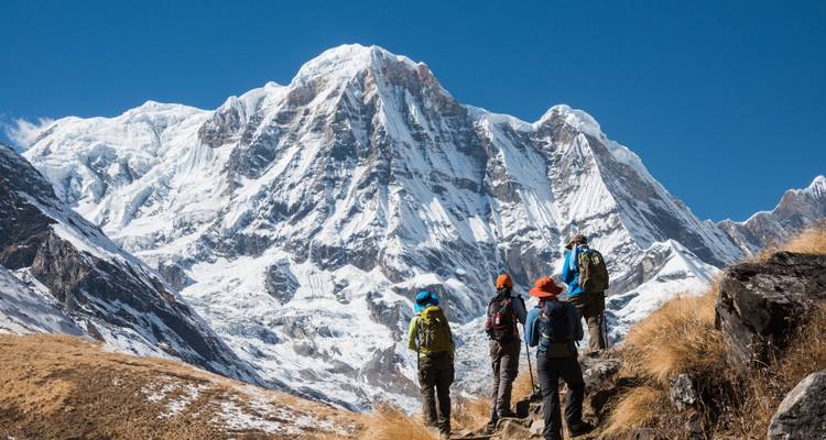 Groep wandelaars kijkend naar het Annapurna-gebergte.