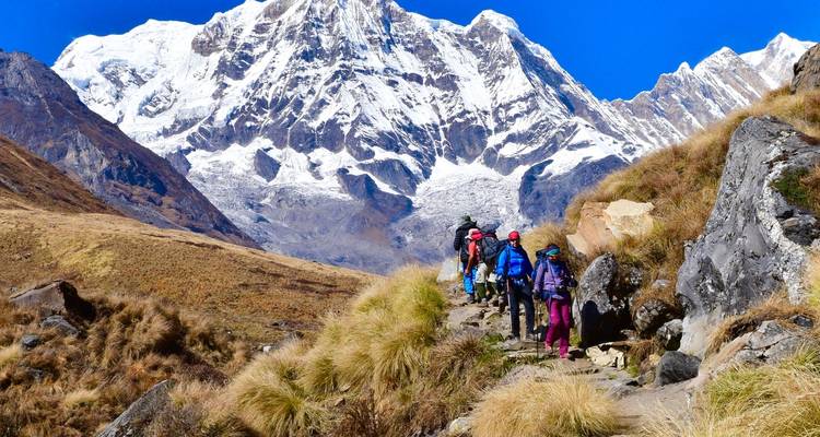 Wandelaars op een pad met de Annapurna-bergketen op de achtergrond.