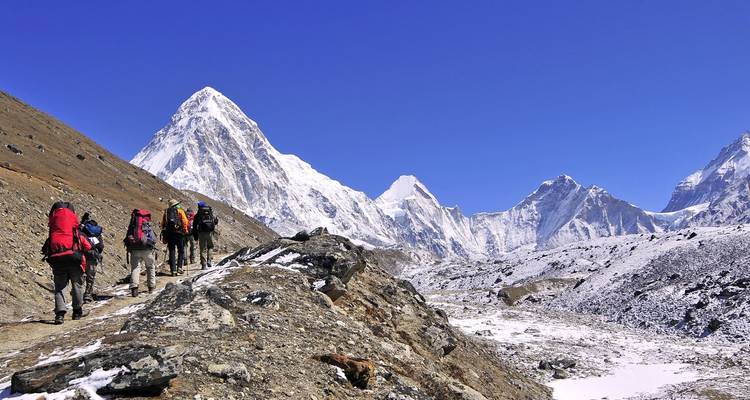 Wandelaars die trekken door een besneeuwde bergachtige landschap.
