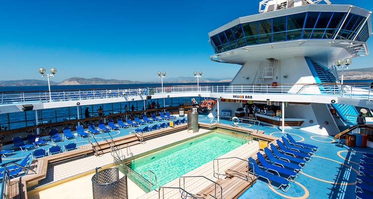 Pont d'un navire de croisière avec une piscine et des transats.