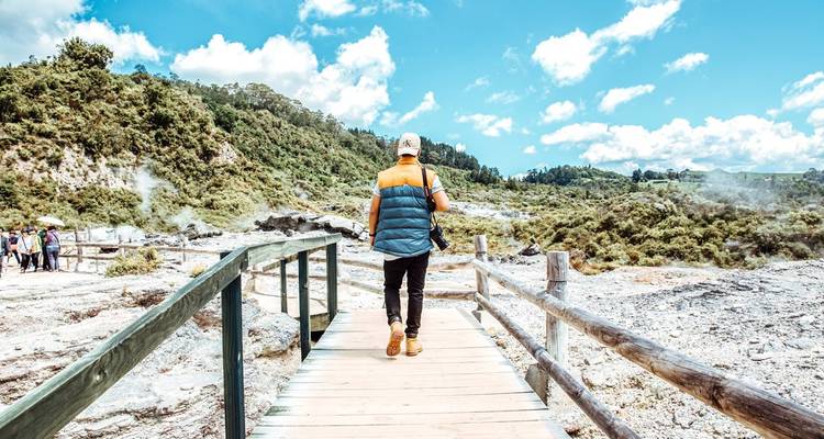Person walking on a boardwalk in a geothermal area.