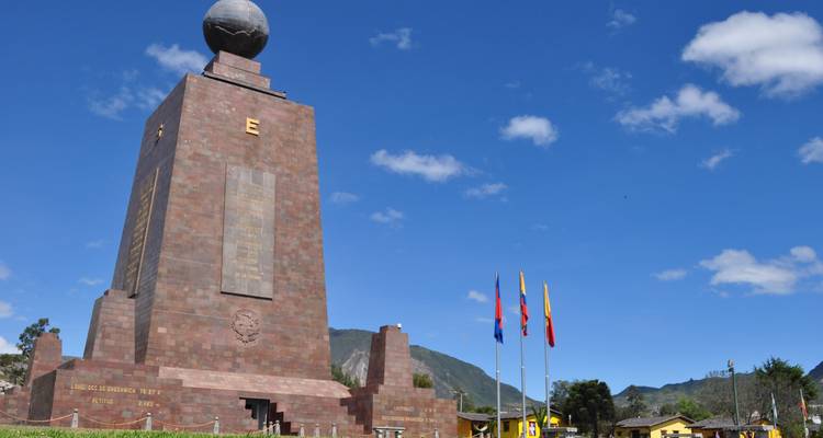Monument to the Equator in Quito, Ecuador under a clear blue sky.