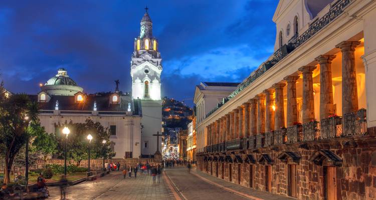 Evening view of colonial buildings with people walking in Quito, Ecuador.