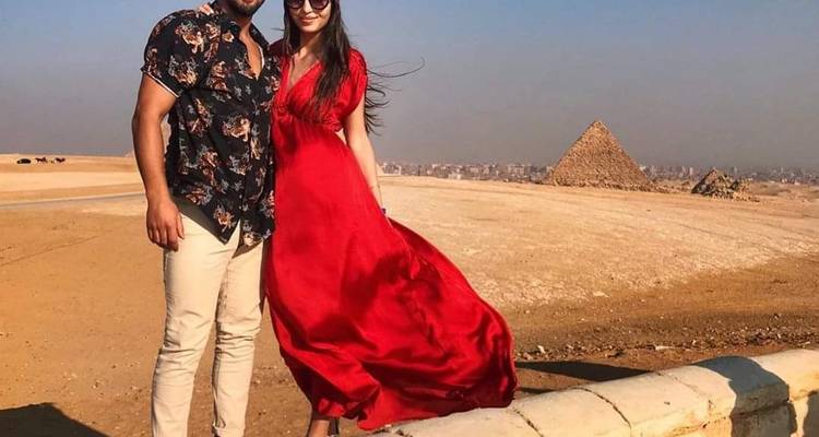 Zwei Personen posieren mit Pyramiden im Hintergrund.