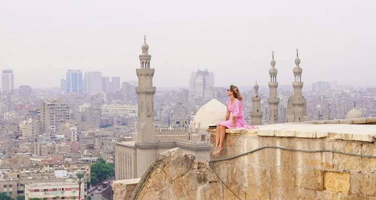 Frau, die auf einem Vorsprung sitzt und auf Kairo blickt.