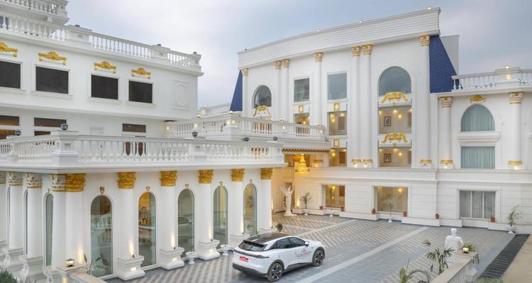 Elegante edificio blanco con un auto moderno estacionado afuera.