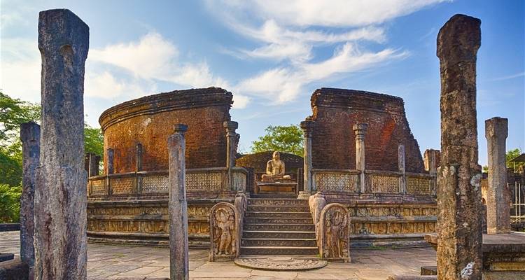 Antike Strukturen mit einer zentralen Buddha-Statue und offenem Himmel.