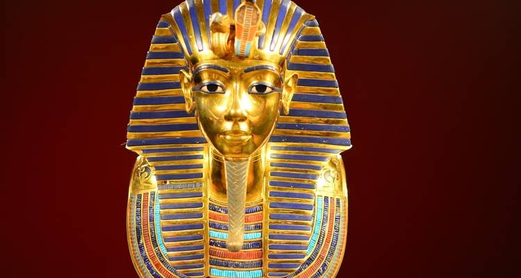 Magnificent gold artifact with detailed carvings and an intense red background.