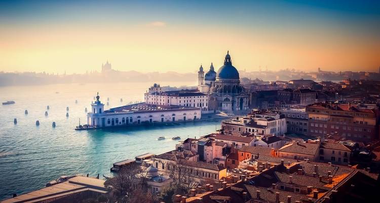 Vista aérea del amanecer sobre el Gran Canal de Venecia con la Basílica de Santa María della Salute y una suave bruma.