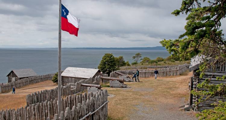 Historische Festung mit chilenischer Flagge am Meer.