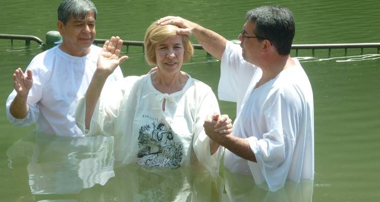 Group of people participating in a religious ceremony in a river.