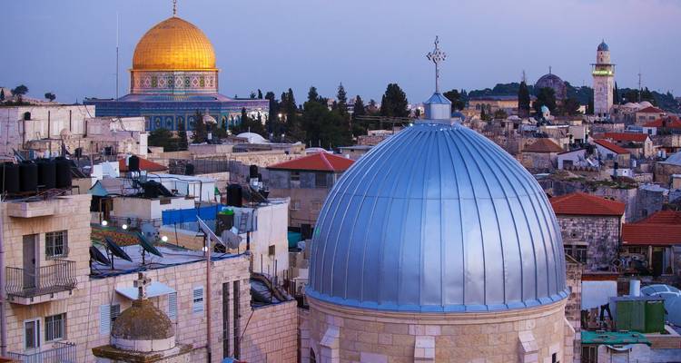 City skyline featuring a prominent mosque and other buildings.