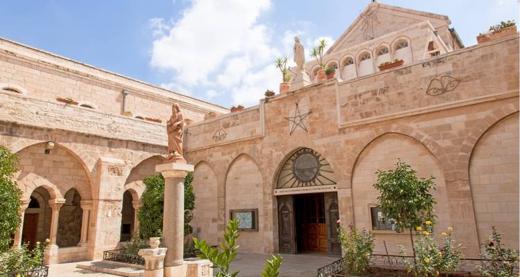 Historic courtyard with arched entrances and statues.
