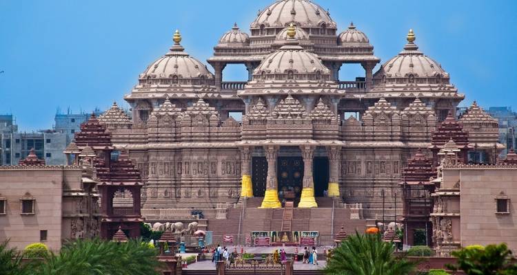 Akshardham Tempel met ingewikkelde architectuur tegen een blauwe hemel.