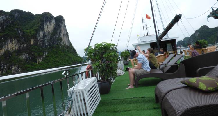 Mensen die op een bootdek zitten met uitzicht op kalkstenen kliffen.