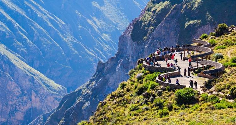 Toeristen bij een uitkijkpunt met uitzicht op diepe ravijnen.