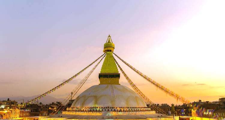 Stupa with prayer flags during sunset.