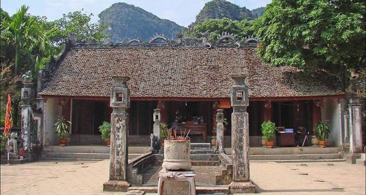 Templo vietnamita tradicional con montañas de fondo.