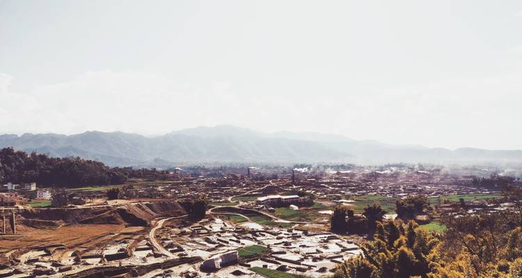 Wide view of a town with mountains in the background.