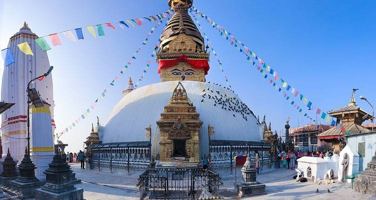 Panoramic view of a stupa with people around.