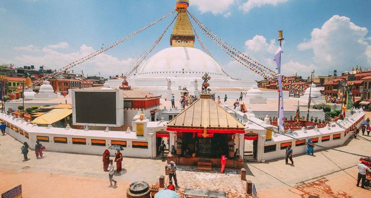 Courtyard surrounding a large stupa under a clear sky.