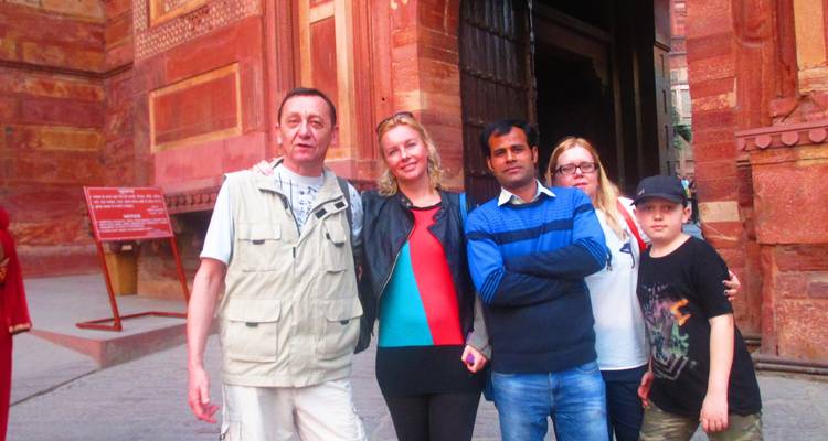 Tourists posing in front of a red brick building.