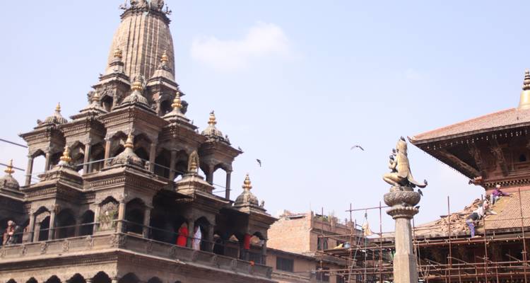 An ancient temple complex with intricate details and a statue.