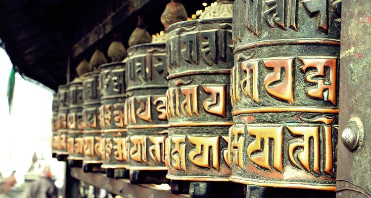 Prayer wheels with inscriptions in a row.