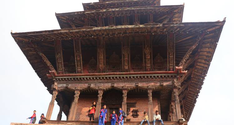 People on the steps of a historic pagoda-style building.