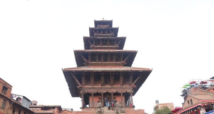 Temple surrounded by people with detailed statues in Bhaktapur.