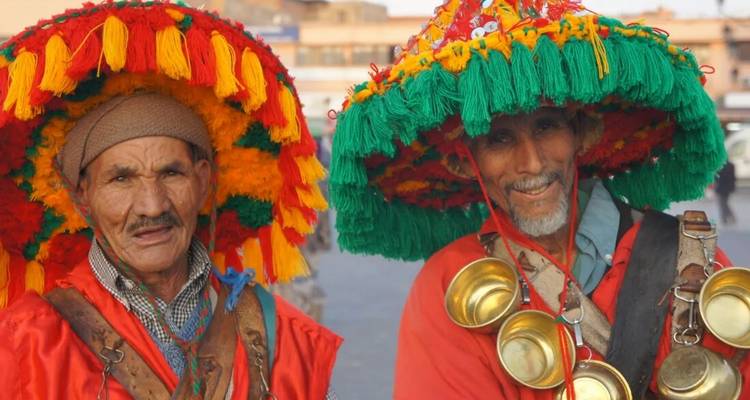Deux hommes portant des chapeaux traditionnels colorés et des vêtements.